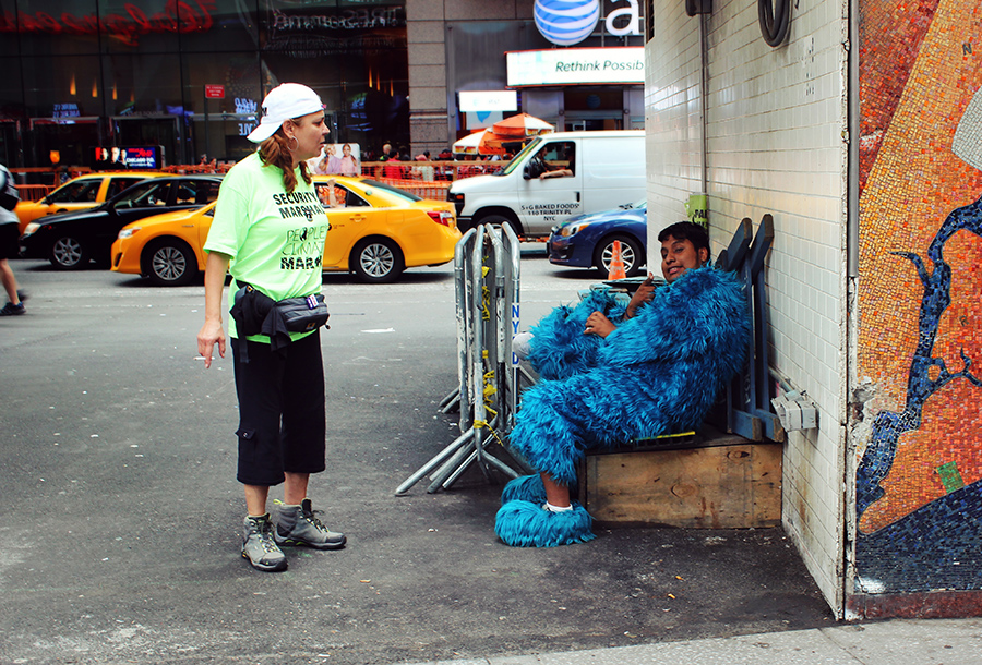 Young man in Elmo costume with security marshal by Phil Price